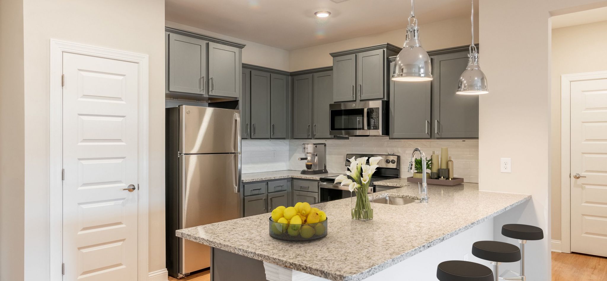 Hawthorne at the Crest apartment kitchen interior with kitchen island, stainless steel appliances, and white cabinetry